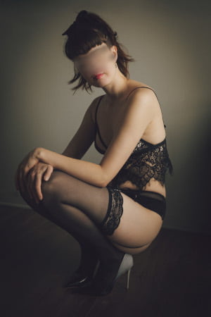 Slim auburn haired girl with her hair tied up kneeling